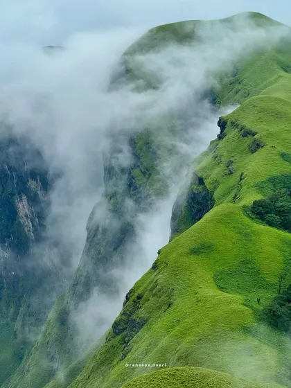 Witness the raw beauty of the Western Ghats from Netravathi Peak. This is the kind of breathtaking view we live for, with clouds swirling around the sharp, green ridges. It’s a perfect shot of the wild, untouched nature we explore.