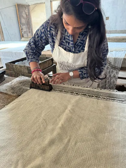 A close-up of me carefully printing a border on a rug using the Dabu technique. Precision is key to ensure the pattern is continuous and even across the fabric.