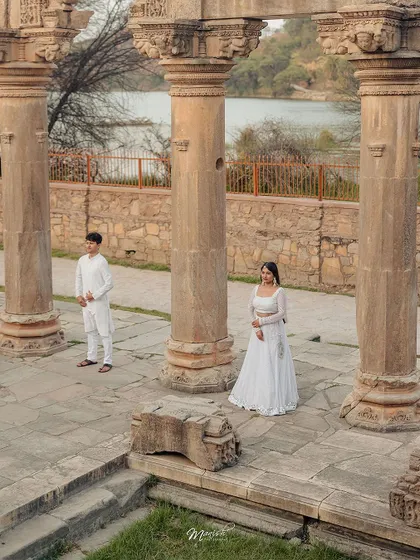 A portrait that plays with distance and connection, showcasing the couple within the grandeur of their historical pre-wedding shoot location.