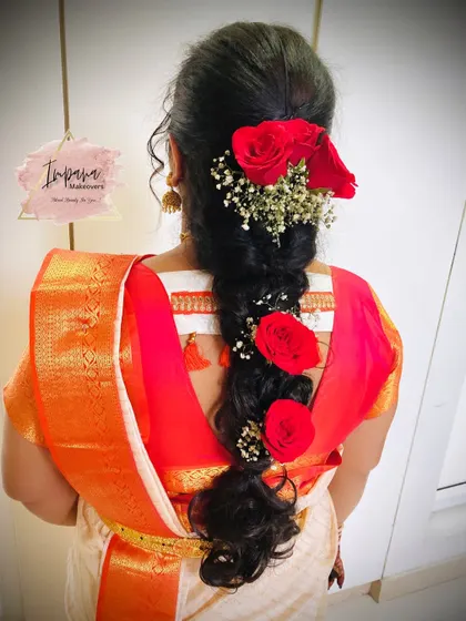 A pretty messy braid adorned with fresh red roses. This hairstyle is perfect for a non-bridal look at a wedding, adding a touch of romance and color.
