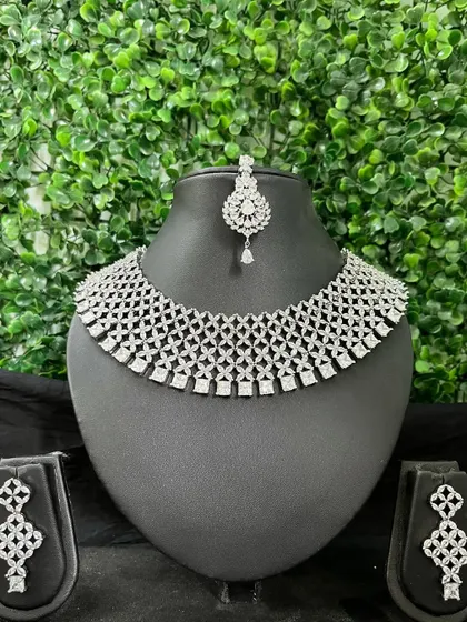 A full American Diamond choker set with a delicate web-like pattern, complete with matching earrings and maang tikka.