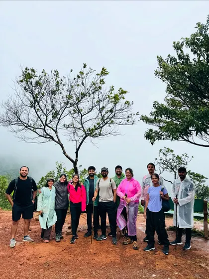 Posing by a distinctive tree on the Tadiandamol trail, with the misty hills of Coorg in the background.