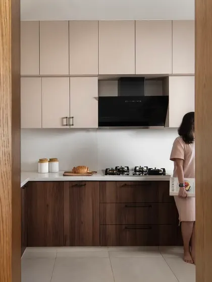This kitchen is a study in contrasts: warm walnut meets muted taupe, grounded by matte black accents. Designed to feel as serene as it is functional, with clean lines and concealed hardware for a minimalist aesthetic.