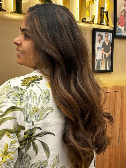 A side view of global highlights, showing how the color is blended to look natural and add a trendy touch to long hair.