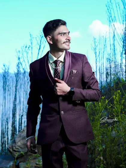 A groom looking dapper in his reception suit. The outdoor location with the bright blue sky adds a cinematic feel to this portrait.