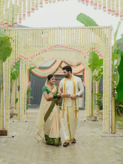 A couple walks through a beautiful walkway decorated with traditional jasmine flower arches, a perfect example of nature-inspired elegance.