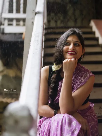 A joyful, candid shot on a wooden staircase during a light rain. The model's bright smile and relaxed pose create an infectious sense of happiness and spontaneity.