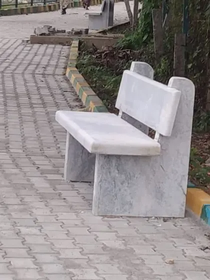 A classic park-style bench made entirely of stone. It's a practical and permanent seating solution for any outdoor space.