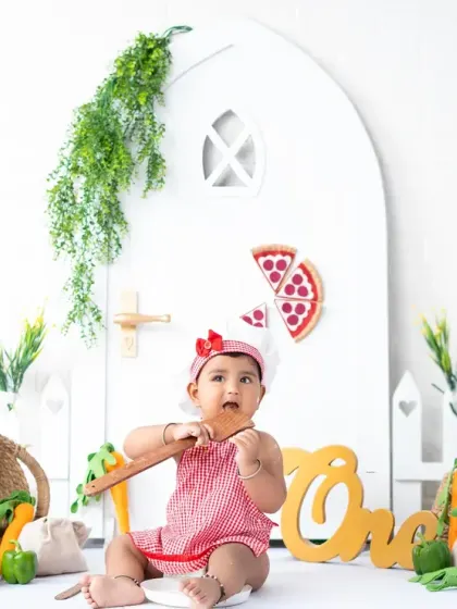 A curious little chef exploring the props in her custom-designed kitchen set. These interactive setups keep toddlers engaged and happy during their session.