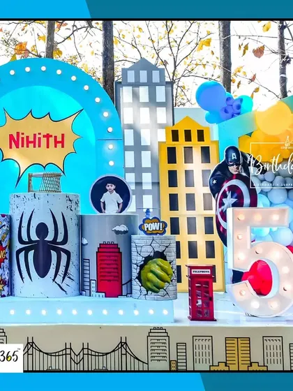 A closer look at the superhero stage for Nihith's 5th birthday. The setup includes a city skyline, comic book-style props, and a light-up number "5".