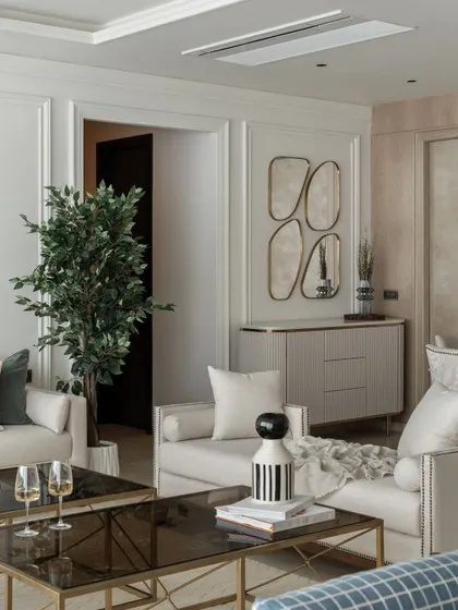 A perfect example of sophisticated elegance. This living room corner features clean-lined furniture, indoor plants for a touch of nature, and unique wall mirrors that act as art pieces, reflecting light and adding depth.