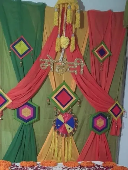 A unique draping style for a Mehendi backdrop, using green, yellow, and red fabrics to create a layered and textured look, complemented by hanging props.