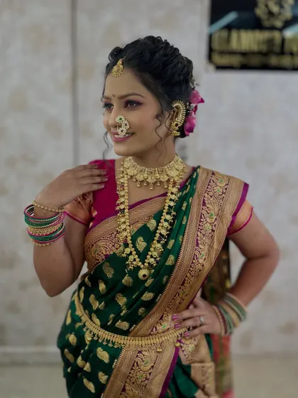 The model posing to show off the full look, including the saree drape, jewellery, and hairstyle.
