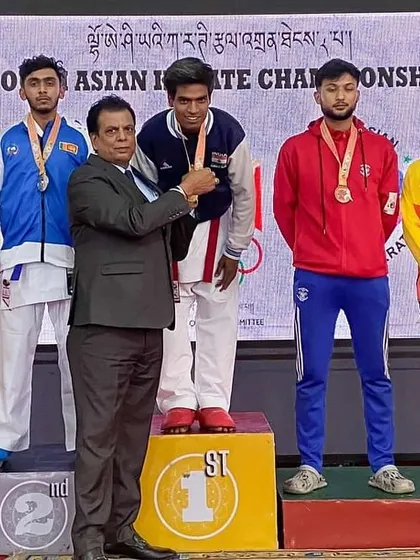 An official presenting the medal to my student Harshit at the South Asian Karate Championship. Each medal is a milestone in their professional karate journey.