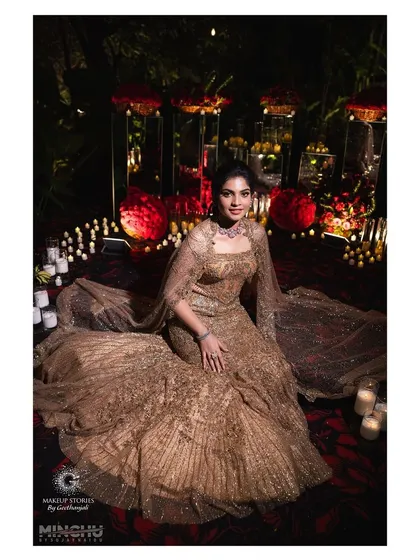A stunning shot of Sindhu seated amidst a grand red decor. Her makeup is perfectly suited for the dramatic and luxurious setting of her engagement party.