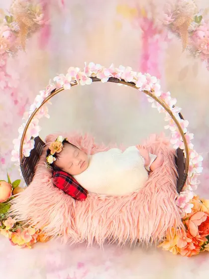 Another angle of the sleeping newborn in the floral swing, showing the beautiful details of the setup and the baby's peaceful expression.