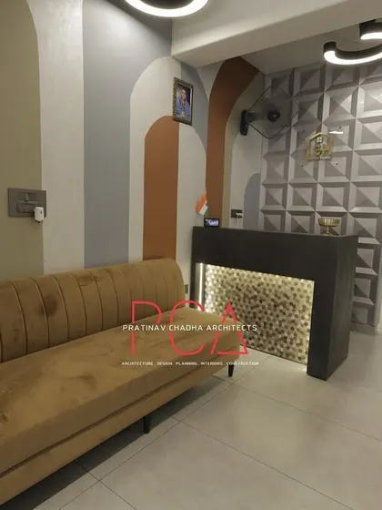 The reception area at StyleIn Homes, focusing on the custom desk with its textured front panel and the welcoming seating area.