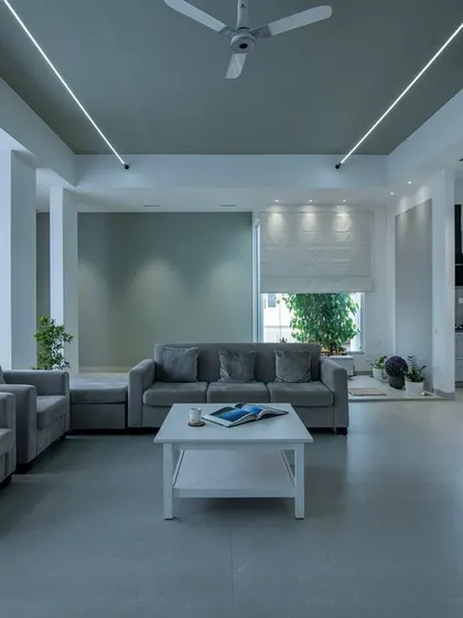 A calm and composed living space designed around a soothing grey palette. The layout is kept simple and functional, with sheer curtains allowing for soft, diffused natural light, creating a perfect atmosphere for relaxation.