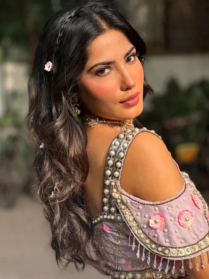 A beautiful over-the-shoulder shot of this Mehendi look. You can see the details of the romantic waves, tiny braids, and delicate floral hairpins.