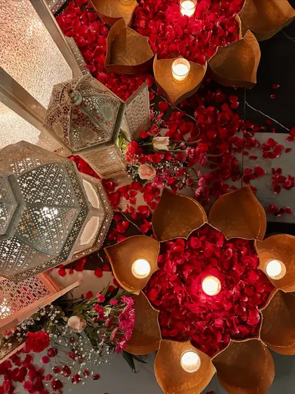 An overhead shot of our Moroccan decor, with intricate lanterns and lotus-shaped candle holders filled with red rose petals.