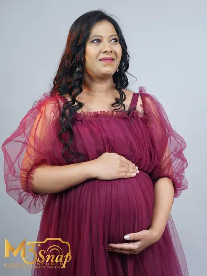 A profile shot that beautifully highlights the baby bump. The soft, dreamy expression on the mother's face captures the wonder of pregnancy.