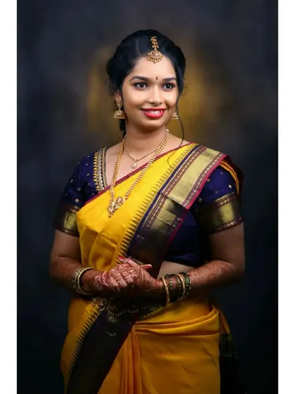 For this client's Varpooja ceremony, we chose a classic South Indian look. The makeup features defined eyes and a bright lip, complementing her beautiful yellow silk saree and traditional gold jewelry.