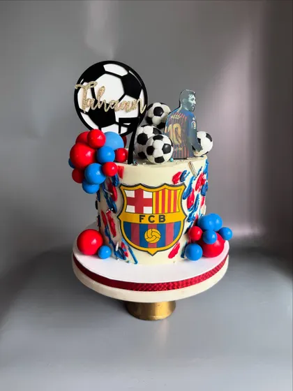 A vibrant soccer-themed cake for Tahaan, a 7-year-old Messi fan. This eggless Chocolate-Dulce de leche cake is decorated with the FCB logo and lots of soccer balls.