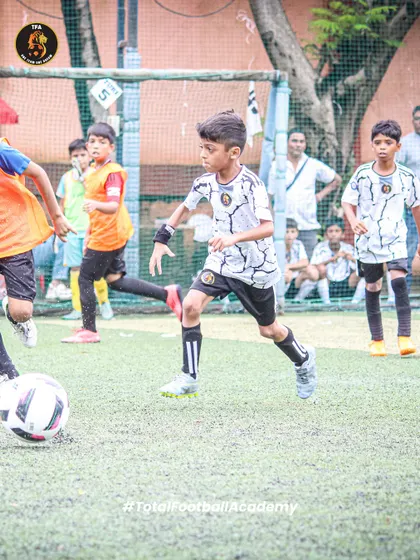 Dribbling through the defense. A player skillfully maneuvers the ball past an opponent in a fast-paced game.