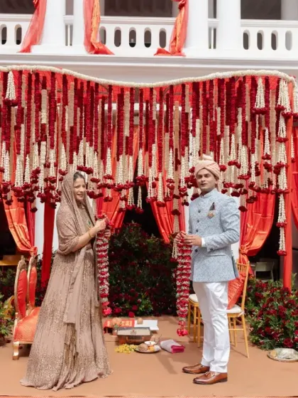 A beautiful moment of union. We designed this wedding stage with a backdrop of red and white floral garlands, creating a classic and romantic setting that perfectly framed the couple as they exchanged their vows.