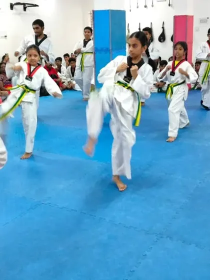 A class of students practicing their kicks together.