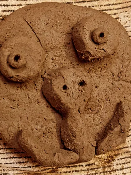 A whimsical face sculpted from lake clay, showcasing the wonderful imagination that is unlocked through working with natural materials.