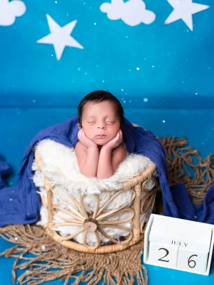 A sweet newborn portrait with a "twinkle twinkle little star" theme. The deep blue background and starry props create a dreamy, celestial vibe for your baby's photos.