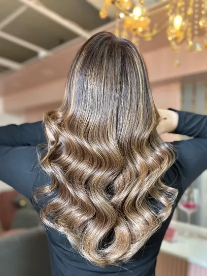 A back view of this beautiful balayage with soft, flowing waves. The highlights are expertly blended to create a natural, sun-kissed effect with incredible shine.