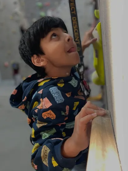 The look of concentration! This young climber is completely absorbed in solving the puzzle of the route in front of him, a key part of what makes climbing so engaging.