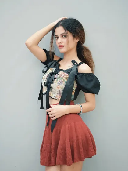 A simple and clean portrait against a grey wall, ideal for a model's portfolio or a casual lookbook.