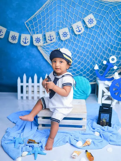 A slightly different pose from the same sailor session. The addition of the sailor cap and the wooden crate as a seat adds variety to the gallery.