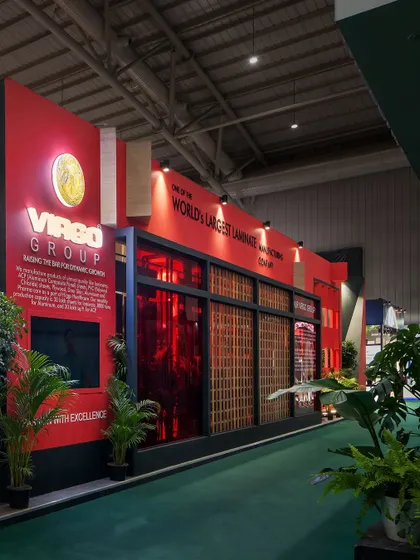 The long facade of the Virgo stall showcases the brand's identity with a bold red wall and large-scale graphics. The design uses translucent panels and strong vertical lines to create a visually engaging and impressive presence.