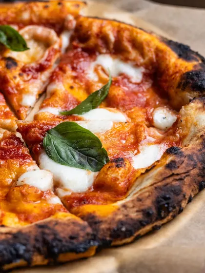 A close-up of a classic Margherita pizza, sliced and ready to be shared. Or not. Sometimes a pizza this good is all for you.