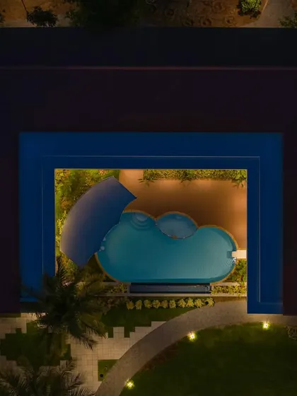 A night view of the clubhouse pool, demonstrating how lighting design creates a dramatic and inviting atmosphere for evening relaxation and entertainment.