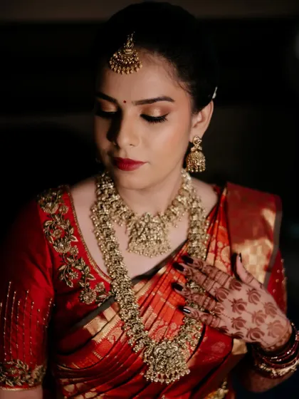 The final look for bride Parinitha. She looks absolutely regal in her red Kanjivaram saree, with makeup that is both traditional and glamorous.