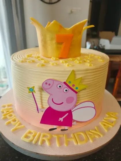A royal Peppa Pig cake, where Peppa is a fairy princess with a crown and wand. The glittering gold crown on top is fit for birthday royalty.