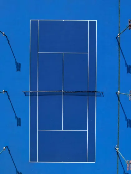 A top-down, symmetrical view of our pristine hard courts. This perspective showcases the professional layout and quality of our training grounds, where precision and technique are honed daily.