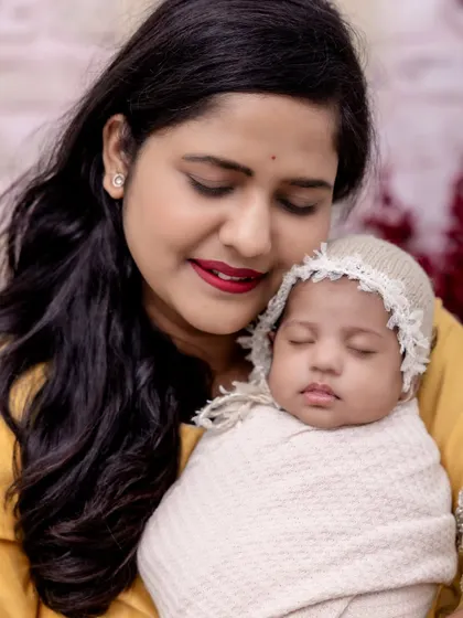 The peaceful bond between a mother and her sleeping baby. We use simple, elegant props like this knit bonnet to add a touch of sweetness to our newborn portraits.
