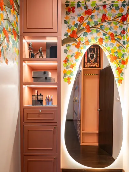 Art can be deeply personal. For this client, we designed a corner around a mural of autumn maple leaves, a nod to their roots. The backlit teardrop mirror and custom shelving create a glowing, personal nook within the master bedroom.