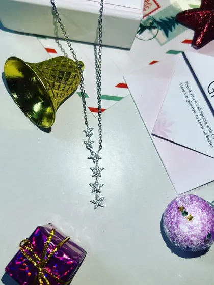A beautifully styled flat-lay of the Giva necklace with Christmas ornaments, creating a perfect gifting vibe for the holiday season.