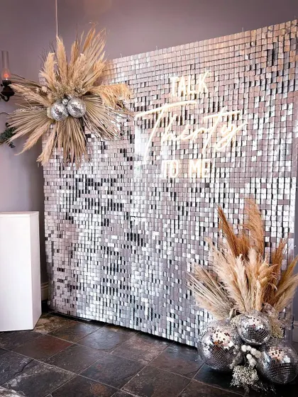 Celebrate a milestone with this glamorous "Talk Thirty To Me" sequin backdrop. The shimmering wall, neon sign, and boho pampas grass accents make it a perfect photo spot for a 30th birthday or bachelorette party.