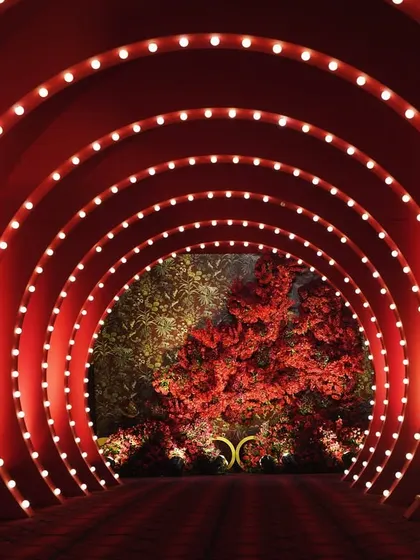 The red vortex entrance tunnel, lined with marquee bulbs, created a sense of anticipation and glamour as guests arrived.