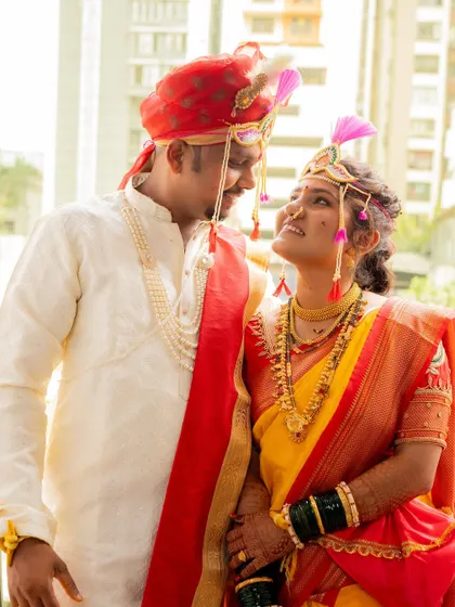 A beautiful photo of the bride and groom looking at each other with adoration, dressed in their traditional Maharashtrian wedding outfits.
