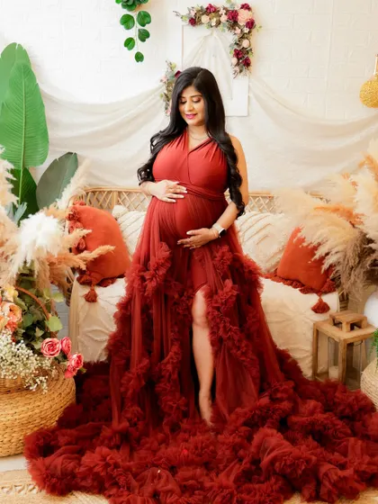 A stunning portrait of a mom-to-be in a voluminous red gown. The rich color and texture of the dress create a dramatic and beautiful image.