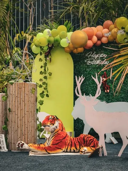 An outdoor jungle theme decoration that can be set up quickly. This design uses a green hedge backdrop, animal cutouts, and bamboo-textured plinths to create an instant jungle vibe.